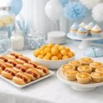 Mesa de buffet de chá de bebê com mini salgados e decorações suaves