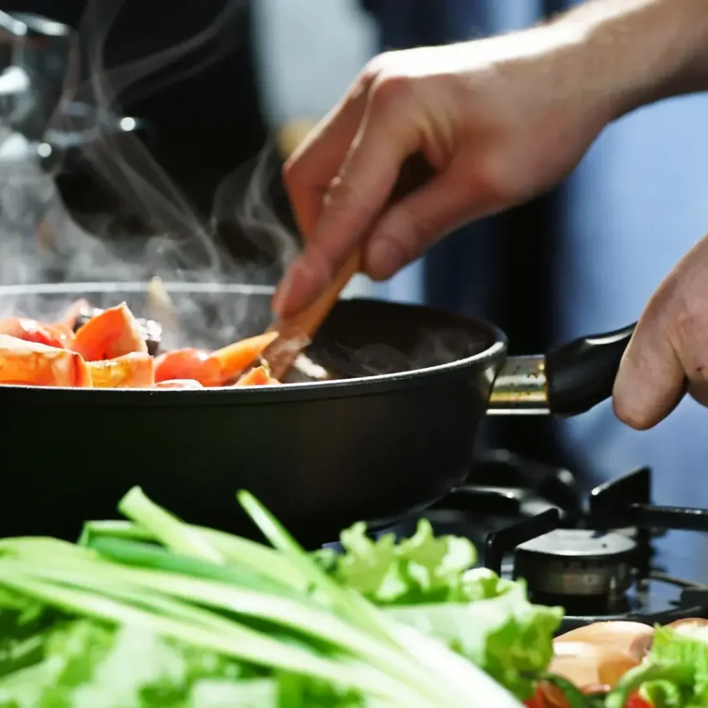 Pessoa cozinhando em um fogão moderno.