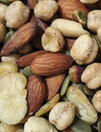 Uma mistura de nozes, amêndoas e castanhas espalhadas sobre uma superfície rústica.