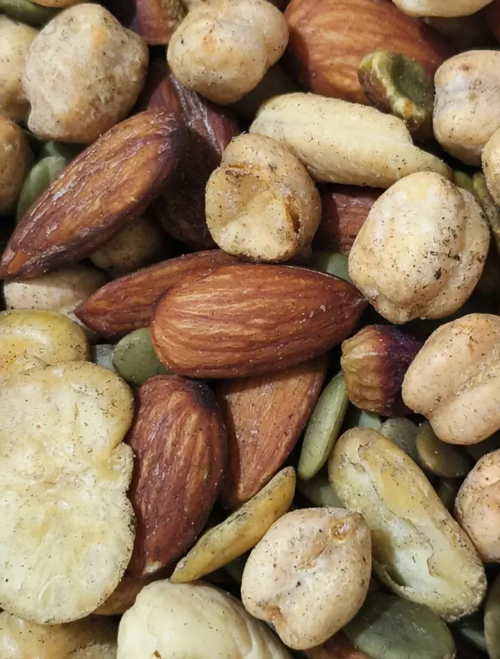 Uma mistura de nozes, amêndoas e castanhas espalhadas sobre uma superfície rústica.